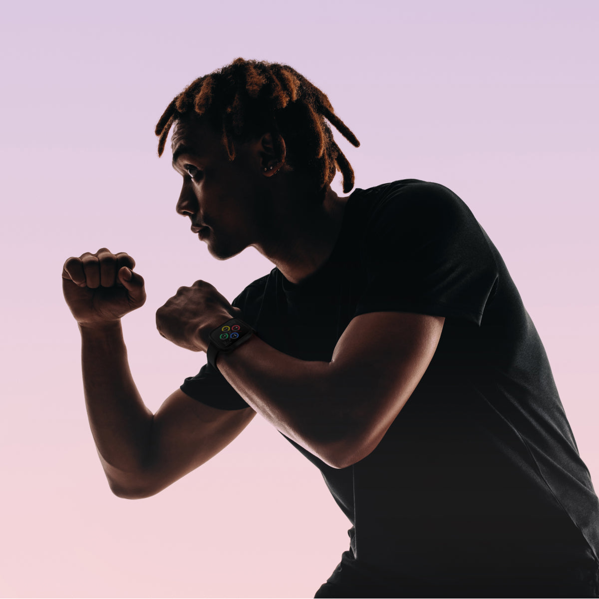 Silhouette of a person wearing a black shirt against a pink background and a air 5 pro smartwatch